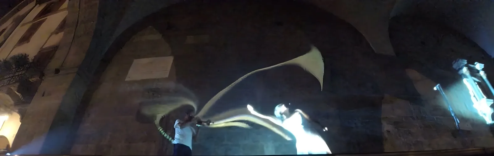 Sotto le volte del Palazzo della Ragione, la scia luminosa nasce dalla tromba e raggiunge la danzatrice